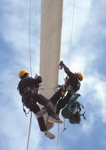 Rope teams repairing a wind turbine blade