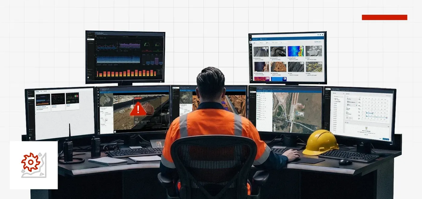 An operator in a control room at a bank of monitors